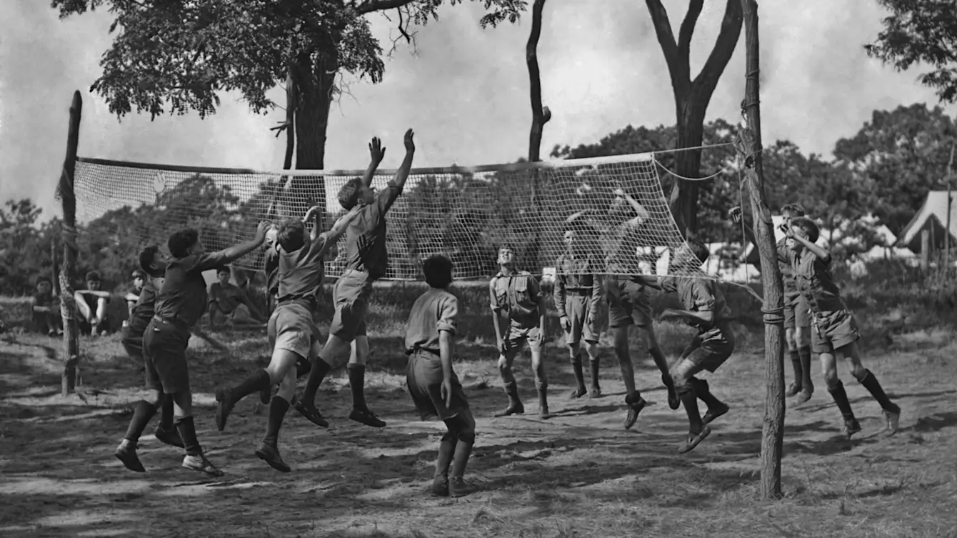 a picture of children playing volleyball back in the day